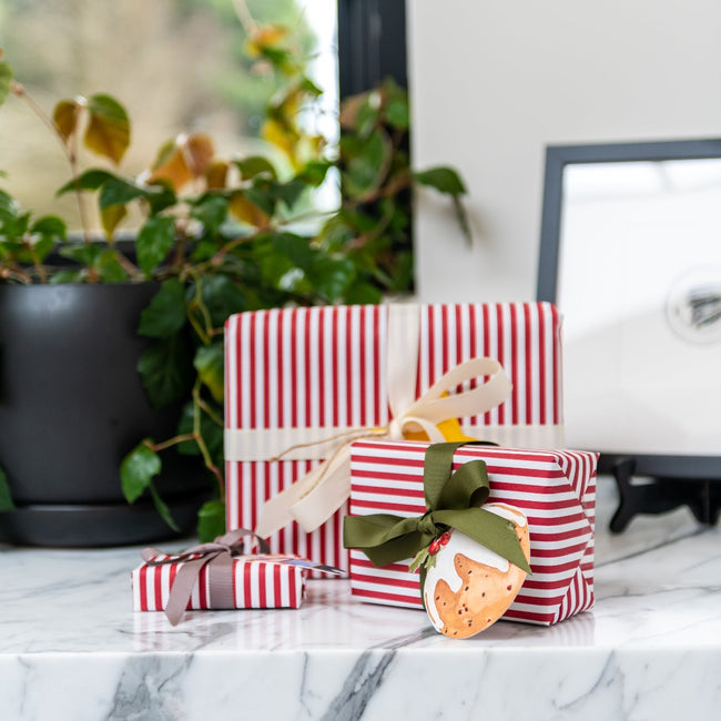 Gift wrapped products sitting on a marble bench, with a gift tag by Sarah Smith